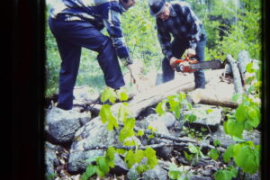 Claire Bombard & Cliff Walker sawing wood